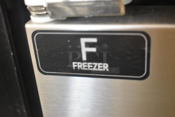 "F Freezer" label on a stainless steel surface of a Unique commercial cooler/freezer unit.