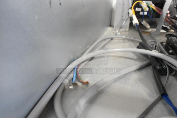 Interior view of a Unique stainless steel commercial reach-in cooler and freezer wiring. Includes visible cables and connections.