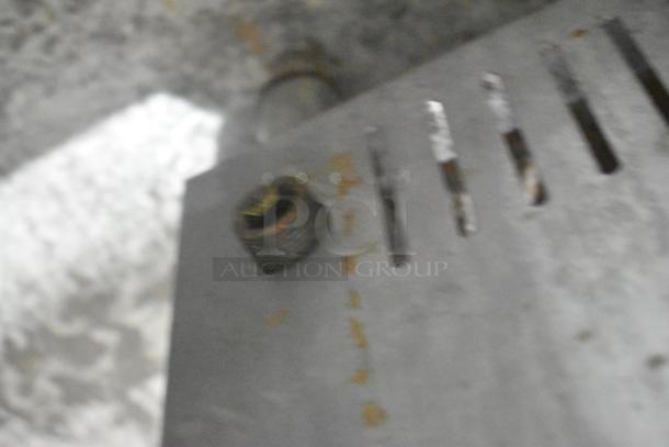 Blurry close-up of L&J OWST-018-2 stainless steel stock pot range part, showing a metal surface with rust marks.