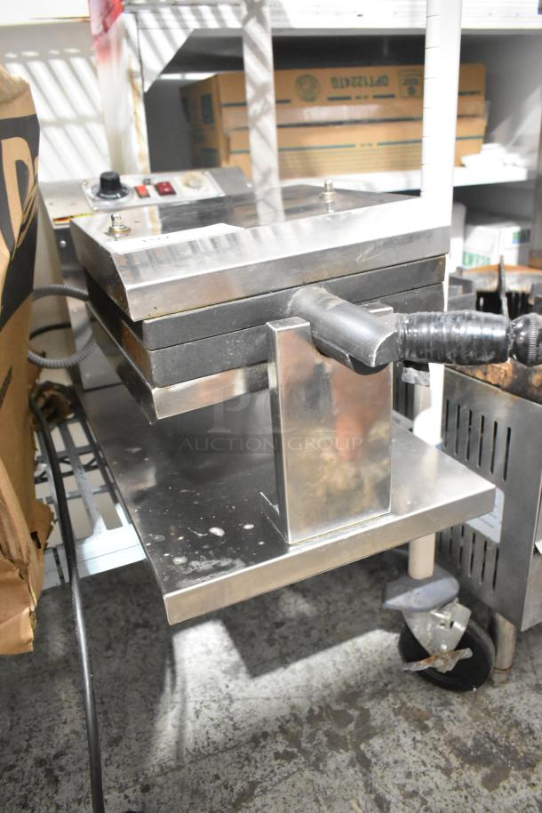 Stainless steel commercial countertop waffle maker with visible handles and control panel; used condition.