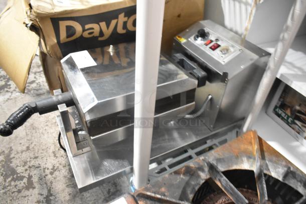 Stainless steel commercial countertop waffle maker with control panel, handle, and durable design. Near Dayton packaging.