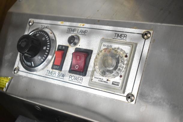 Stainless steel commercial countertop waffle maker with temperature control, timer, and power switches. Used condition.