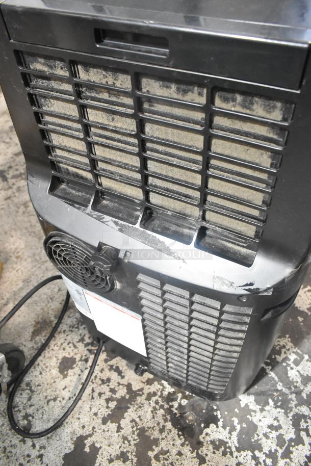 Honeywell MN10CES portable air conditioner, black, showing rear view with dusty vent and attached power cord. Model MN10CES.