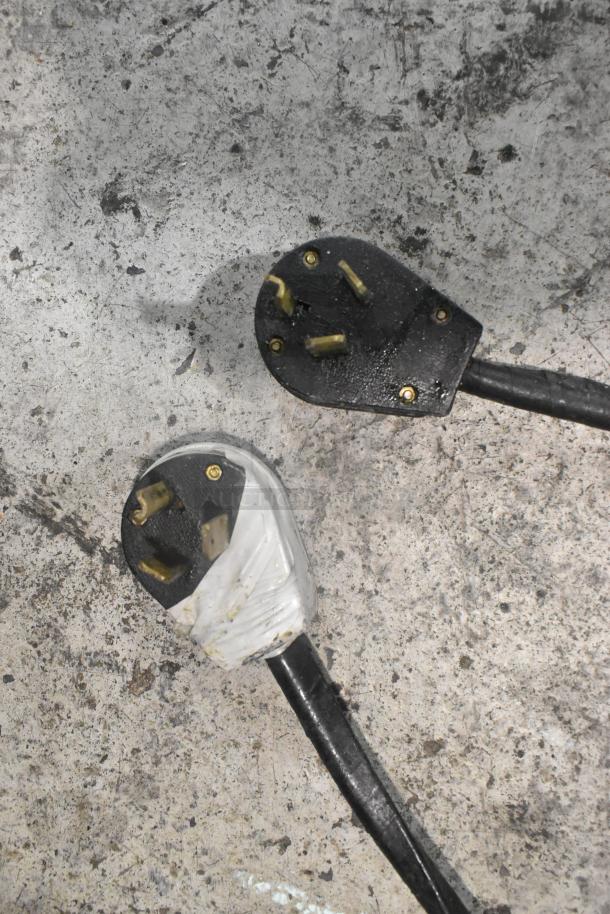 Power plugs for Selm SLT-05THS steam table, showing wear. One plug is wrapped in white tape, indicating potential repair.