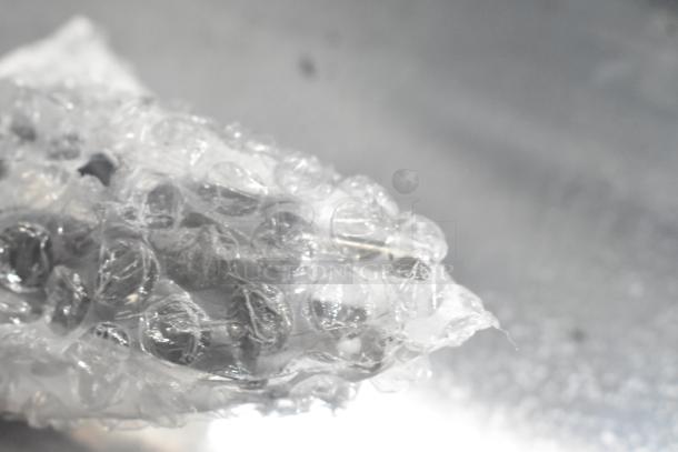 Bubble wrap packaging for the Avantco 177RG1850NS hot dog roller grill, showing new condition protection.