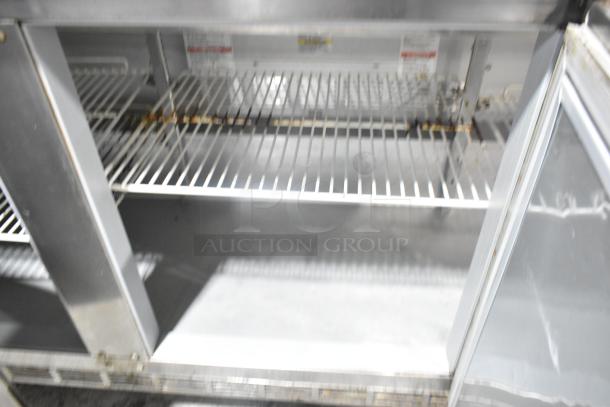 Beverage Air SPE72HC-18 stainless steel prep table with multiple shelves, commercial casters. Visible wear, interior details shown.