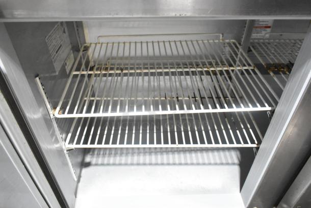 Beverage Air SPE72HC-18 stainless steel prep table interior with wire shelves, commercial model, visible model label, on casters.