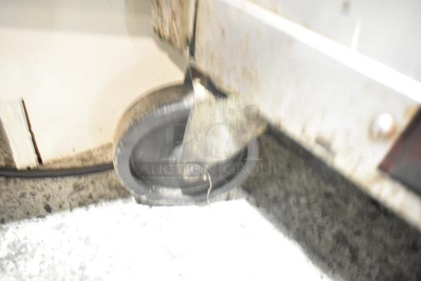 Beverage Air SPE72HC-18 prep table showing one commercial caster, slightly worn condition.