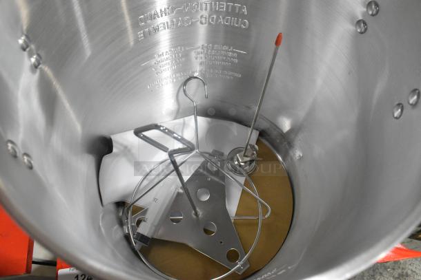Brand new stainless steel deep fat fryer stock pot with minor scratches. Includes metal rack and thermometer. Markings visible inside.