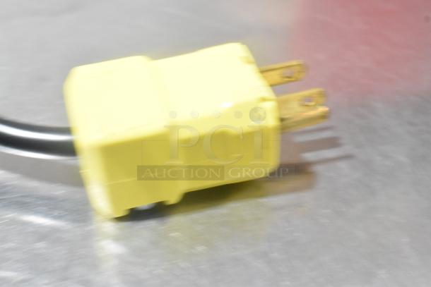 Yellow plug of Pavoni LIRA/E110V semi-automatic dessert slicer, scratch and dent, 110V, 1 phase, on metal surface.