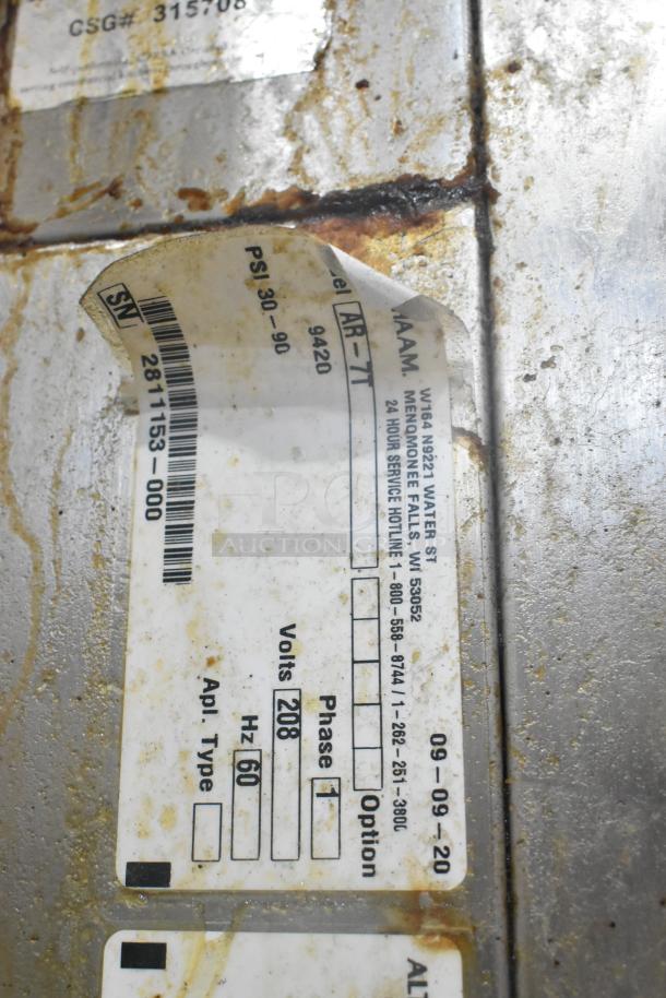 Alto Shaam AR-7T rotisserie oven label showing model, serial number, and specifications. Stainless steel with visible wear.