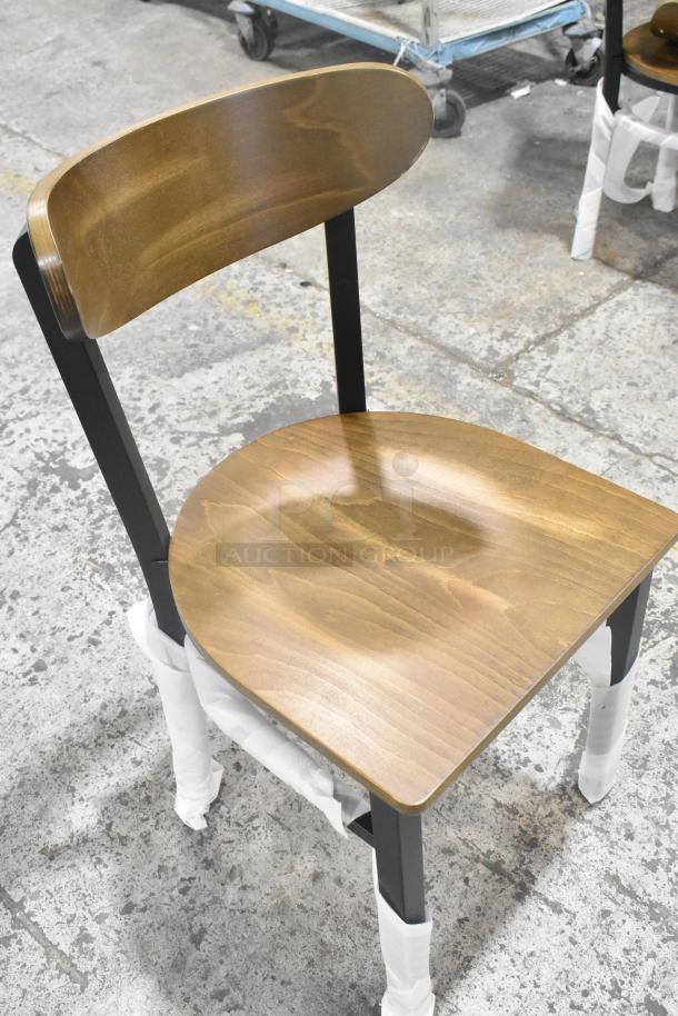 Black metal dining chair with wooden backrest and seat, brand new condition, protective wrap on legs, auction item.