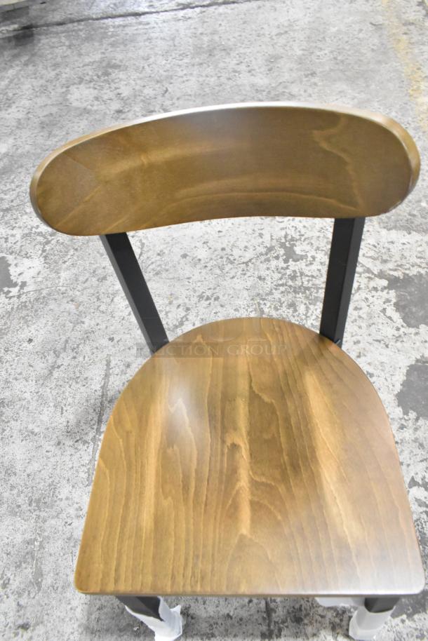 Black metal dining chair, scratch and dent, with a wooden backrest and seat. Brand new, available in bulk.