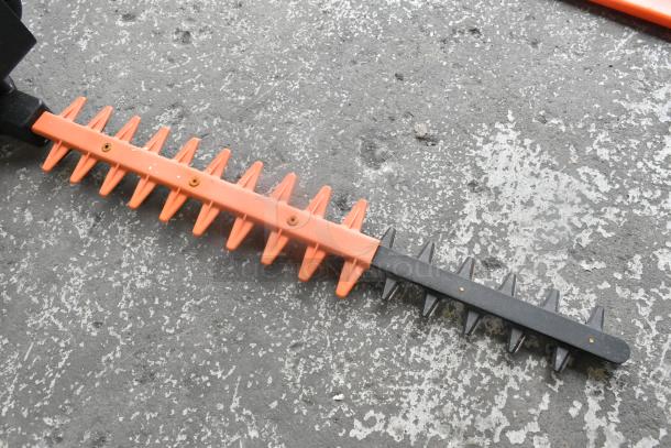 Core CHT410 Gasless Power Bush Trimmer blade, orange and black, showing sharp teeth, used condition.
