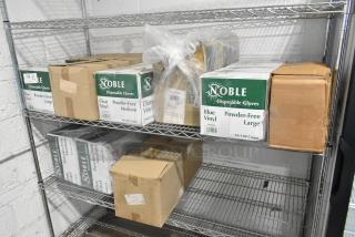 Two-tier shelf with Noble Products disposable vinyl gloves, including 394405L and 394365M models, in original packaging.