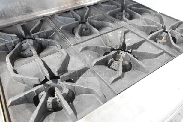 Imperial stainless steel commercial gas range with six burners, flat top griddle, convection oven, and over shelf. Used condition.