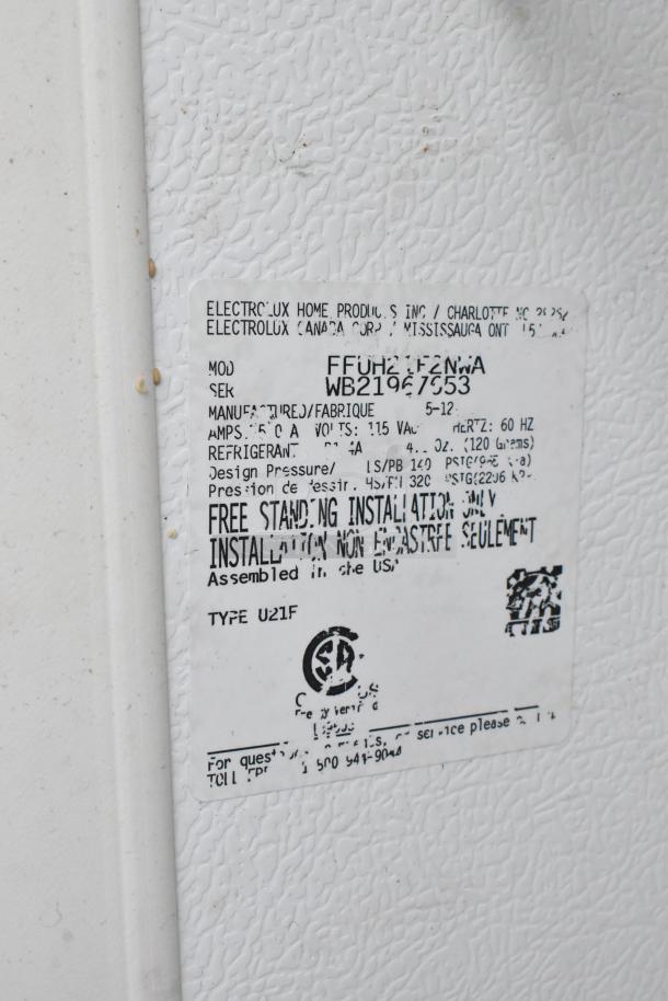 Frigidaire FFUH21F2NWA metal single door reach-in freezer, 115V, 1 phase, label shows model, voltage, and assembly origin.