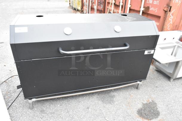 Backyard Pro metal commercial grill with casters, black finish, visible logo, sturdy handle, in used condition.