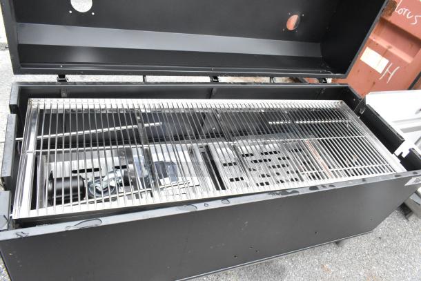 Backyard Pro metal commercial grill with open lid, steel grates, and attached commercial casters, in good condition.