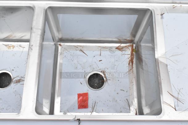 Regency 600S21818218 stainless steel 2 bay sink with dual drain boards. Brand new, minor scratches and dents visible.
