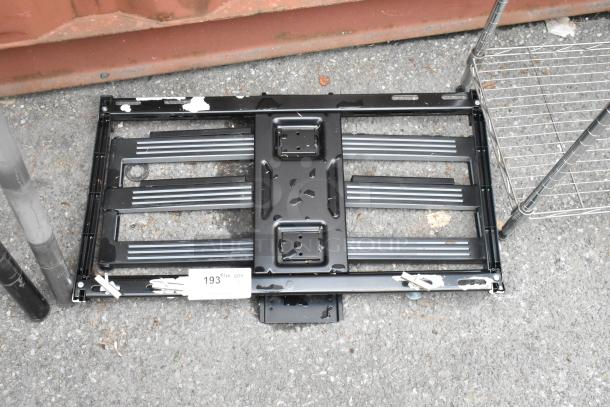 Black metal unit with rectangular frame, horizontal slats, and mounting holes. Some signs of wear and peeling paint. Tag reads "193."