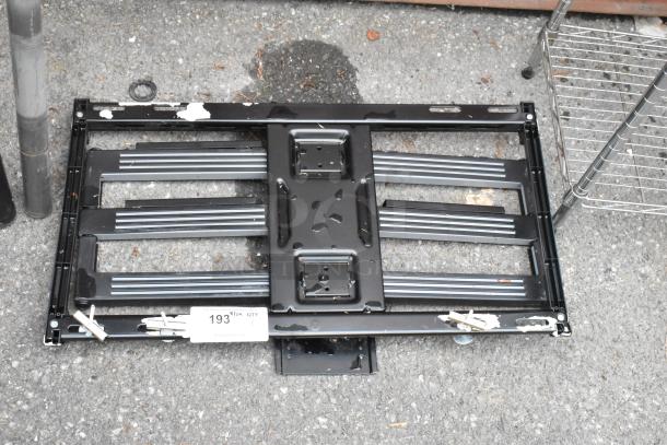 Black metal unit with a grid design, visible wear and paint chipping. Auction tag indicates item number 193.