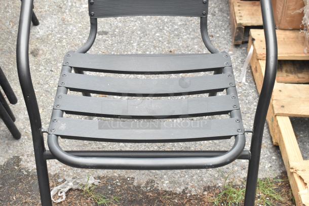 Black metal patio chair with armrests, featuring slat back and seat design, in good condition. Set of 8 available.