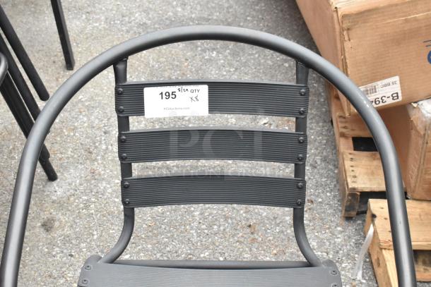 8 black metal patio chairs with armrests, ribbed design. Auction tag reads "195, Qty x8." Durable, modern style.