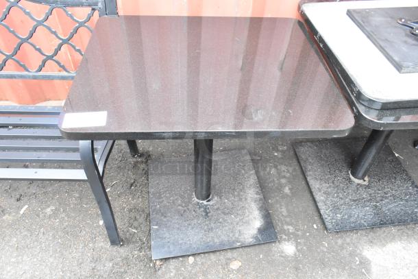 Black stone pattern dining table with black metal base, square top, polished surface, marked tag visible, sturdy condition.