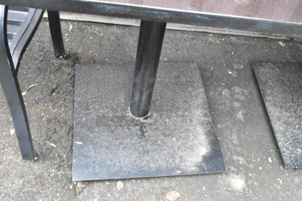 5 black stone-pattern dining tables with black metal bases visible in outdoor setting.
