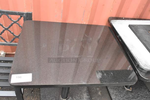 Black stone pattern dining table with black metal base, in good condition. Label indicates item 198.