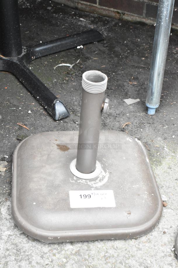 Square metal patio umbrella base with adjustable holder, moderate wear. Visible label with number "199".