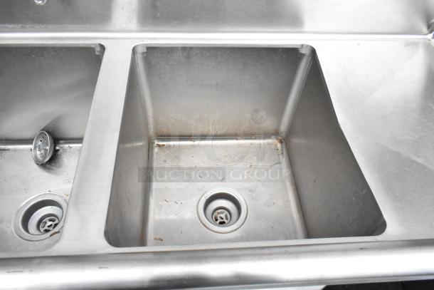 Regency 600S31416212 stainless steel 3 bay sink with dual drain boards, faucet, and handles. Used condition with visible wear.