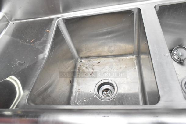 Regency 600S31416212 stainless steel 3-bay sink with dual drain boards, faucet, handles, visible wear, and marks.