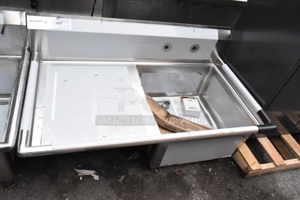Brand new Regency 600S1232324L stainless steel single bay sink with left side drain board, slight scratches visible.