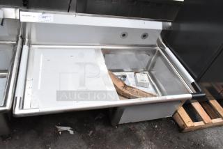 Brand new Regency 600S1232324L stainless steel single bay sink with left side drain board, slight scratches visible.