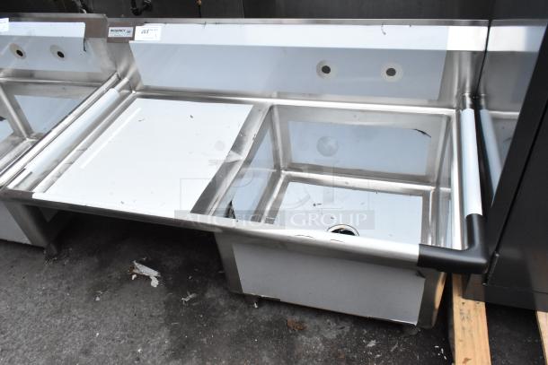 Brand new Regency 600S1232324L stainless steel sink, single bay, left drain board, minor scratches, ideal for kitchens.