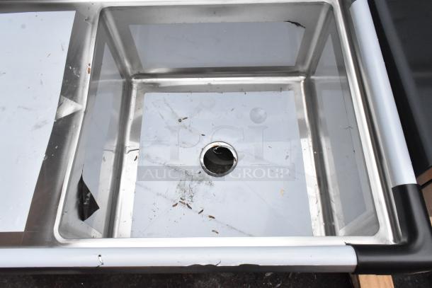 Brand new Regency 600S1232324L stainless steel single bay sink with left side drain board, visible scratches and dents.