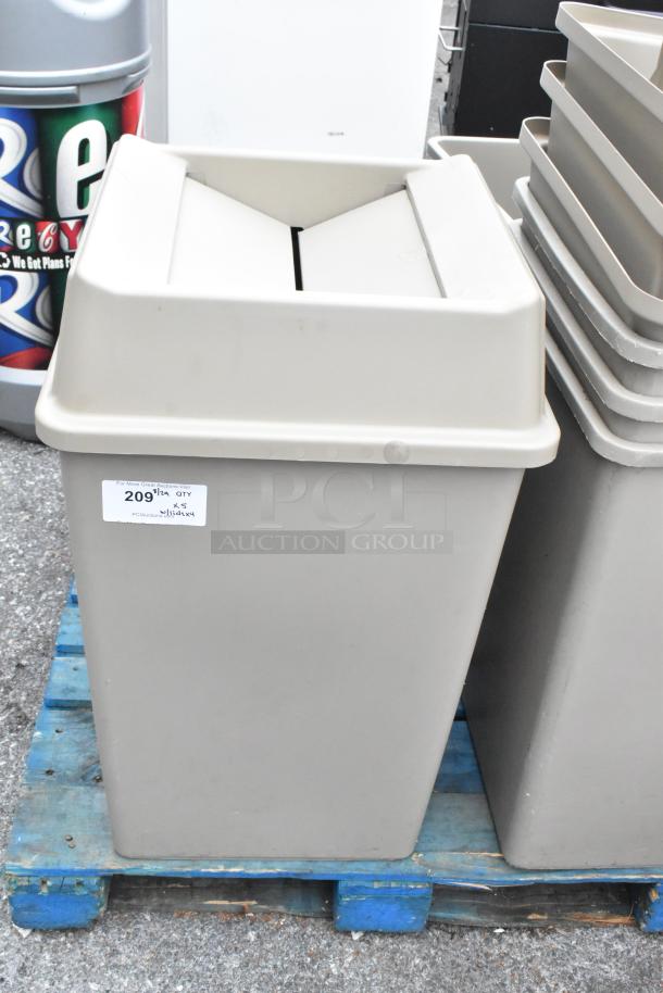 Tan poly trash cans with lids, 5 pieces, scratch and dent condition, on a blue pallet, auction label visible.