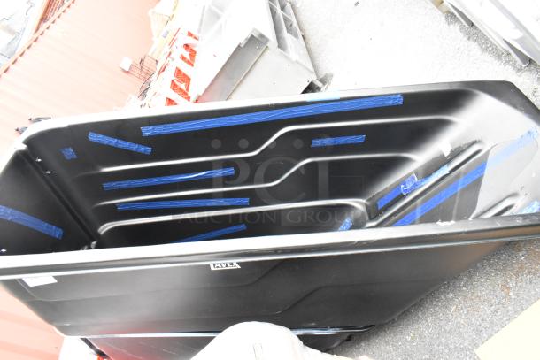 Brand new black poly tilt truck with visible scratches and dents, featuring a large capacity and sturdy design.
