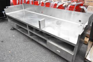 Stainless steel commercial equipment stand with under shelves and 2 drawers, in used condition, featuring a durable build.