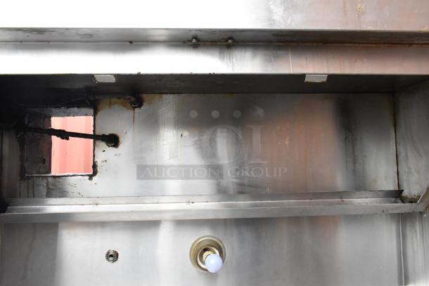 5.5' stainless steel commercial grease hood, showing signs of use, featuring a light fixture and ventilation opening.