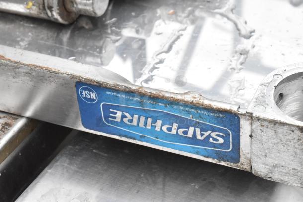 Metal shelf with visible Sapphira label. Exhibits signs of rust and wear. NSF certified.
