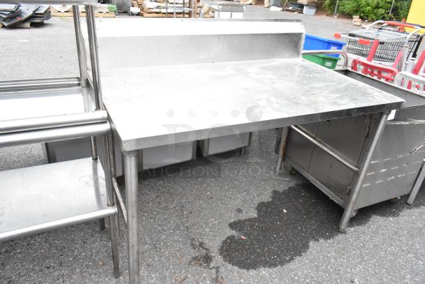 Stainless steel table with backsplash, industrial design, used condition, sturdy construction, ideal for kitchen or workshop.