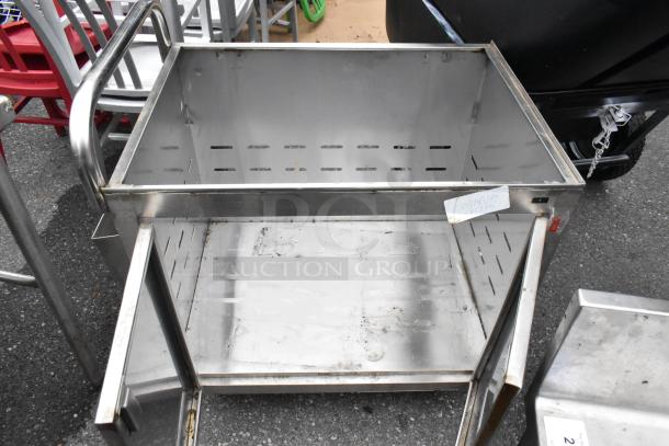 Stainless steel cart with commercial casters, open-top design, sturdy build, visible wear, ideal for industrial use.