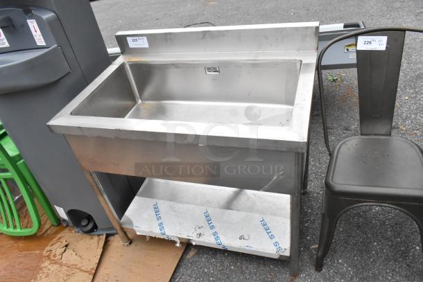 Stainless steel sink bay with under shelf, featuring a spacious basin and sturdy construction. Includes protective film on shelf.