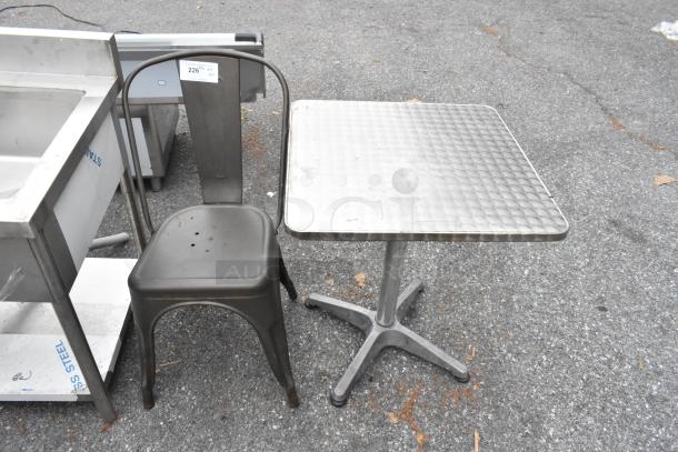 Gray metal Tolix-style chair and chrome finish dining height table, both in used condition.
