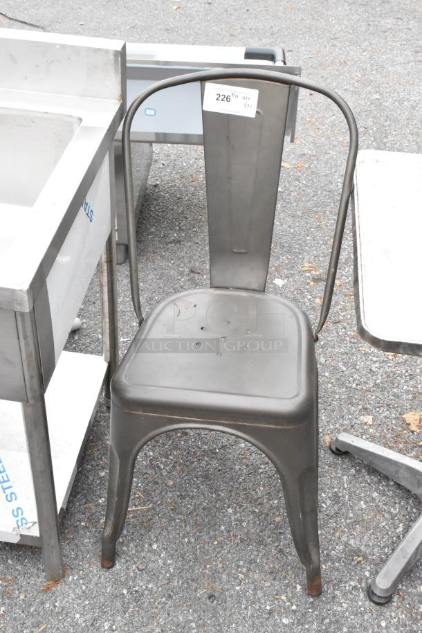 Gray metal Tolix style chair with tag indicating "Qty 1, XL." Features sturdy design, suitable for indoor/outdoor use.