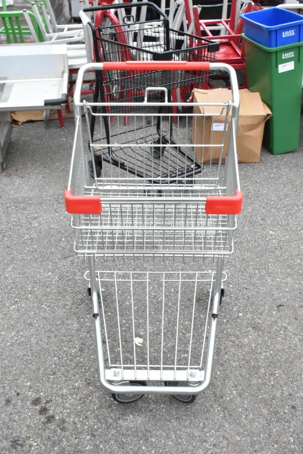 Brand new metal 2-tier shopping cart with red handles, commercial casters, minor scratches, and dents.