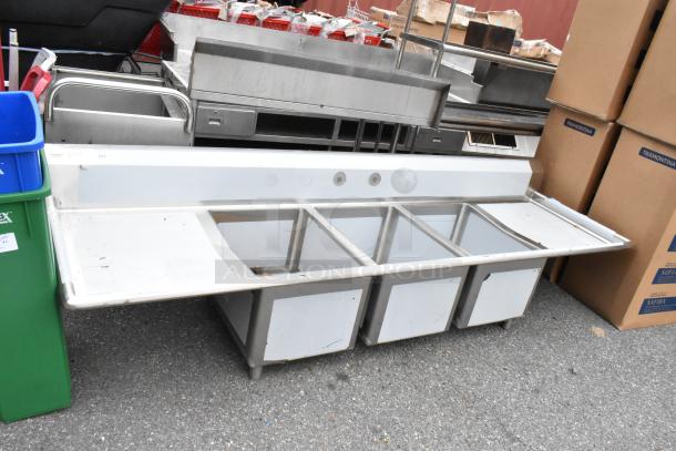 BRAND NEW Regency 600S31824224 stainless steel 3 bay sink with dual drain boards, slight scratches, tags visible.